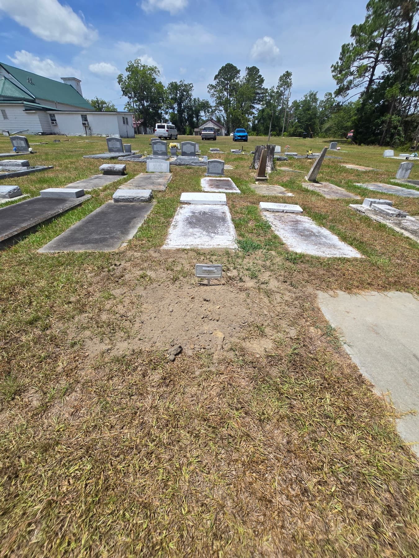 Older slab graves at Live Oak Cemetery, the church beyond